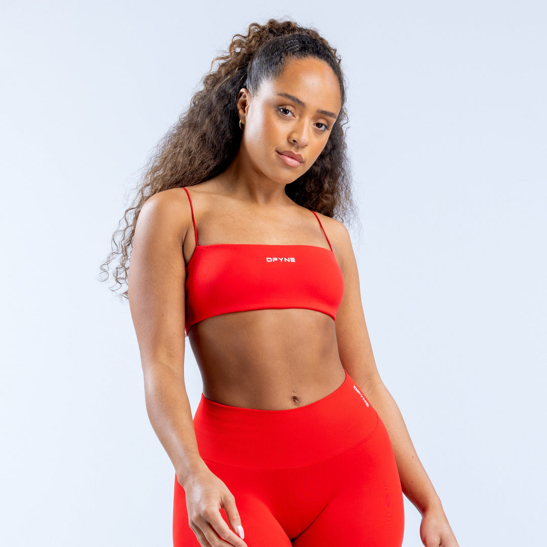 Red strappy sports bra with thin adjustable straps and front logo