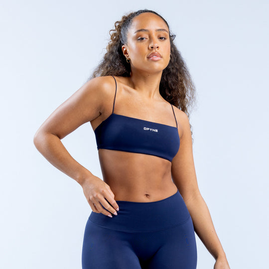 Navy strappy sports bra with thin adjustable straps and logo band