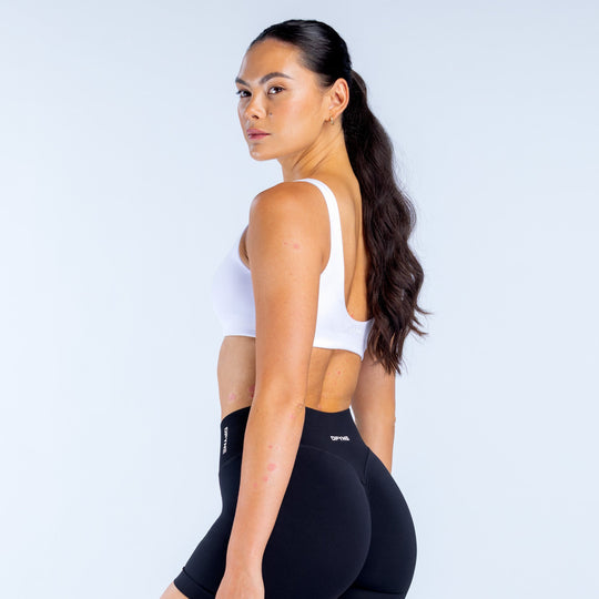 White scoop-back sports bra with visible back straps and wide neckline