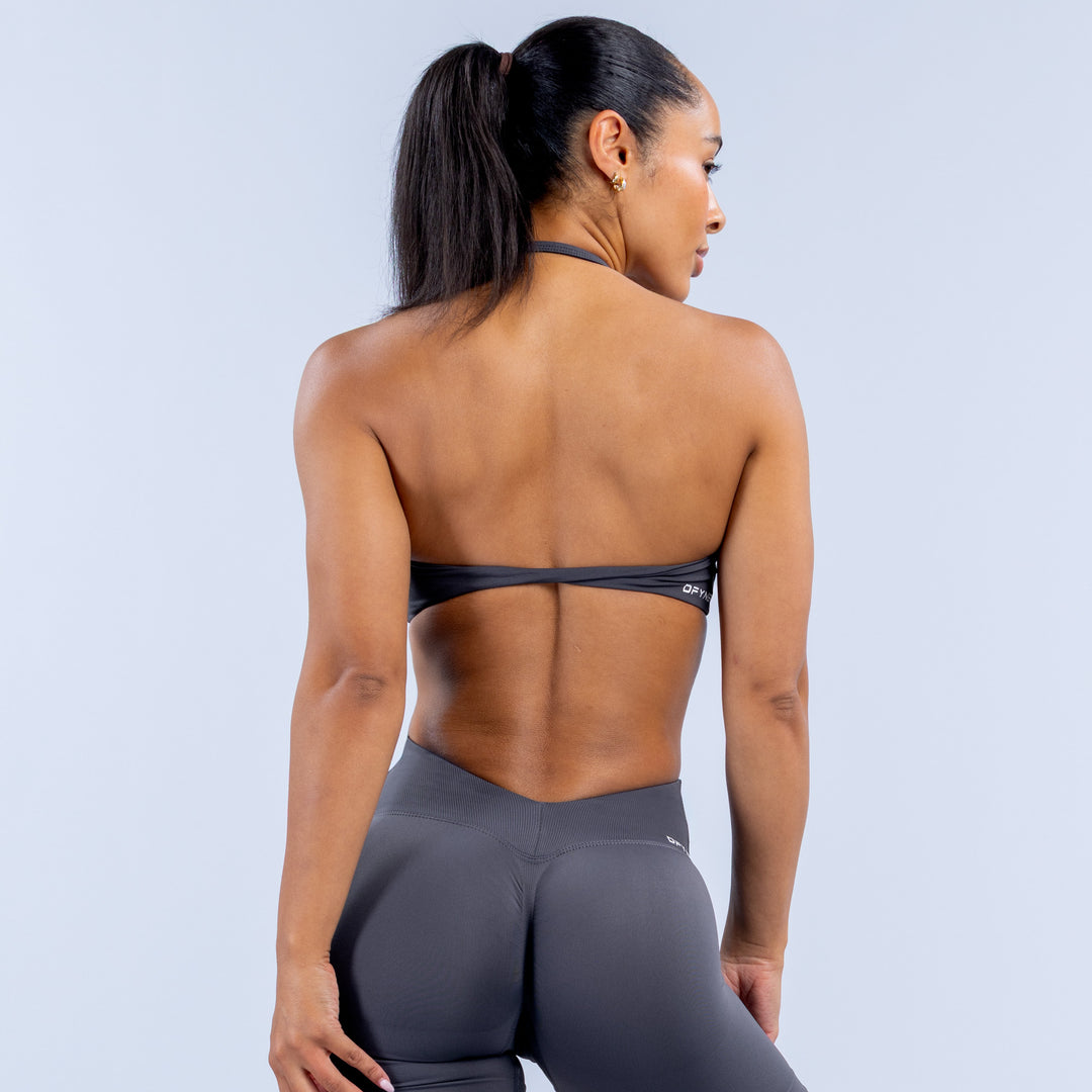 Back view of dark gray high-neck halter sports bra with crisscross straps