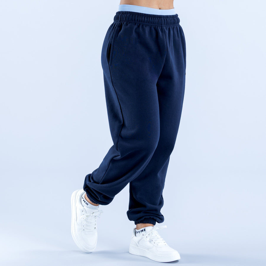 Navy joggers with elastic waistband and ribbed cuffs, back three-quarter view.