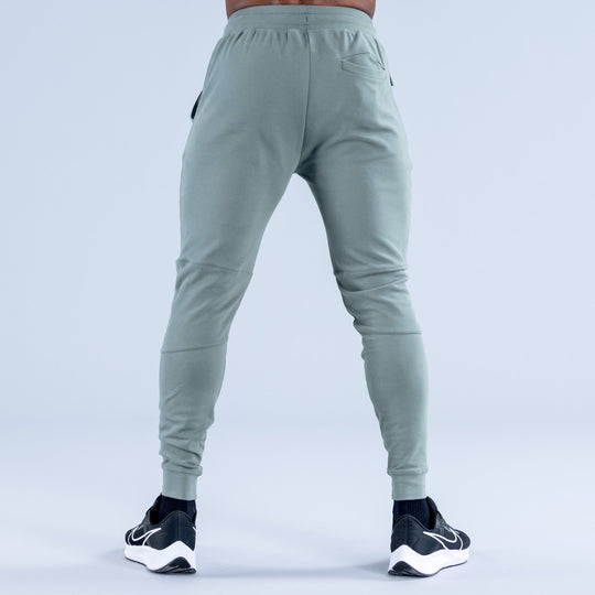 Sage green tapered jogger pants with elastic back waistband and ankle cuffs