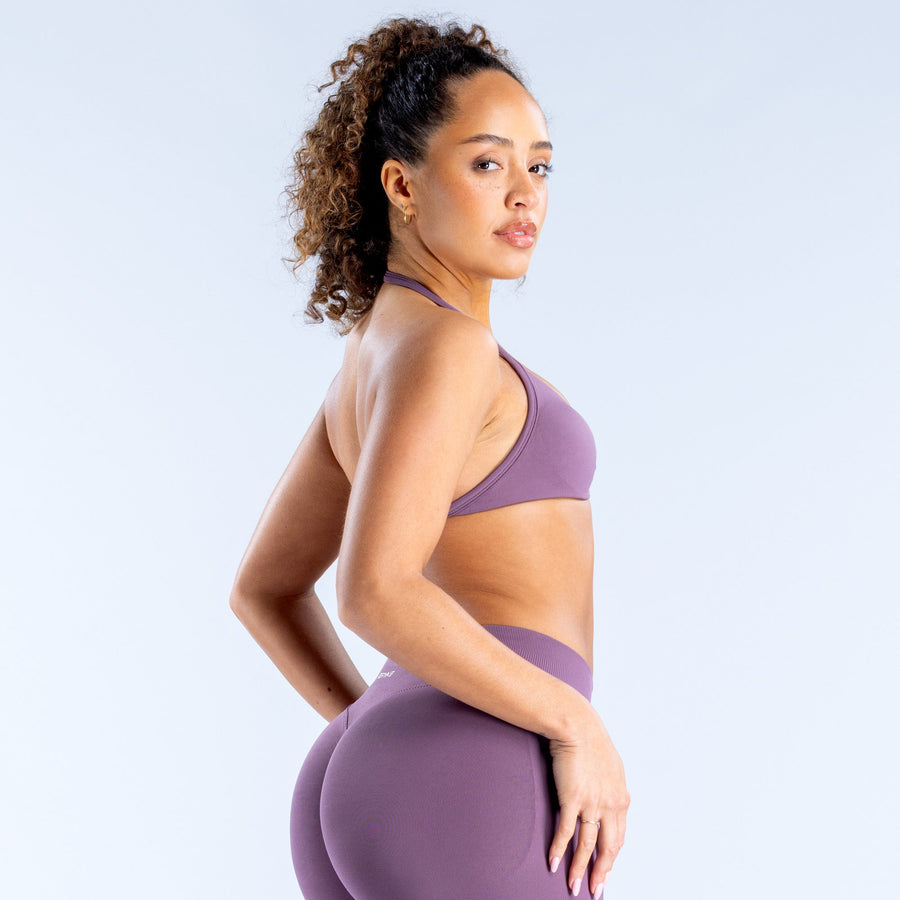 Purple strappy sports bra with thin straps and curved back, side view