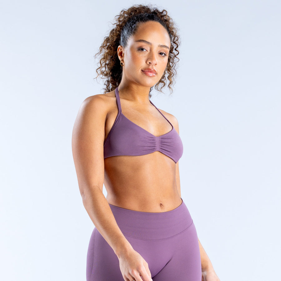 Purple strappy sports bra with gathered front detail and supportive cups