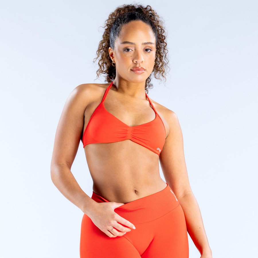 Impact Strappy Bra in bright red-orange with thin straps and ruched front