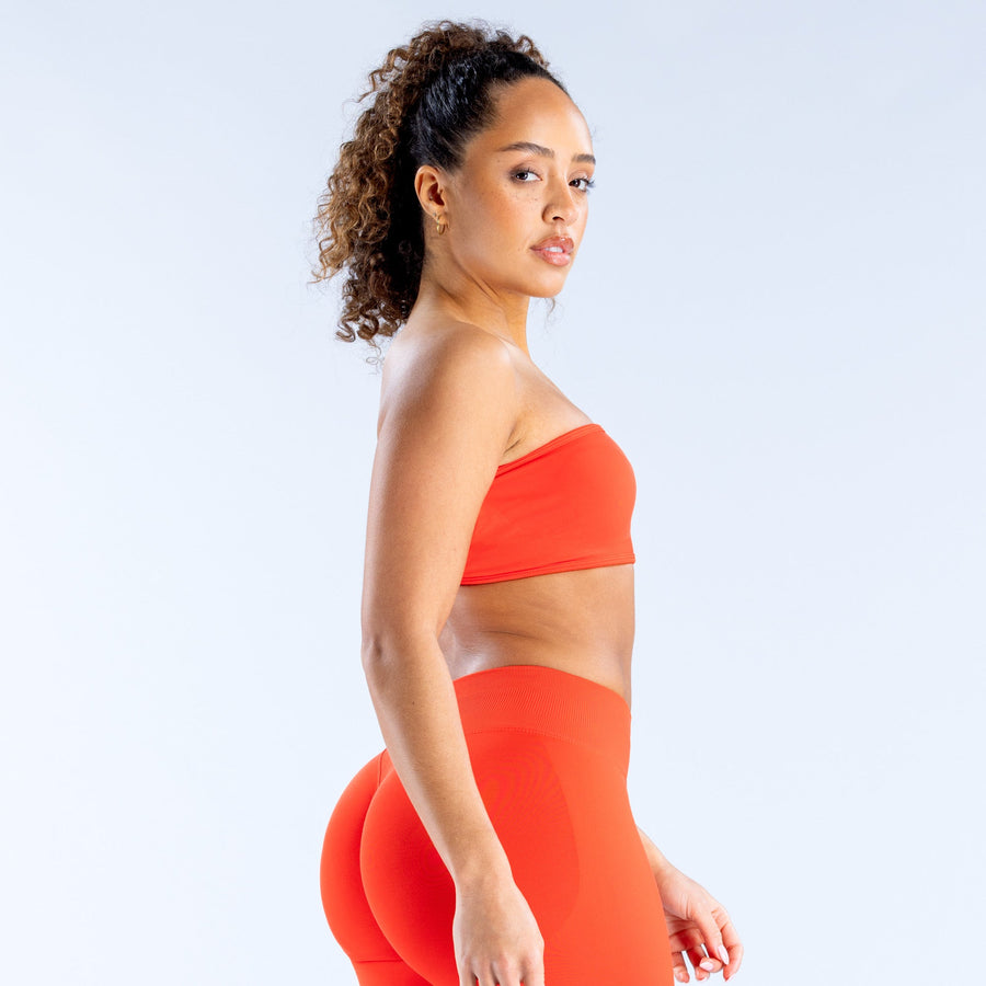 Red bandeau sports bra with smooth fabric and wide elastic backless band detail.