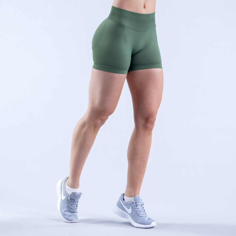 Fitted green athletic impact shorts front view with mid-thigh cut and flat waistband