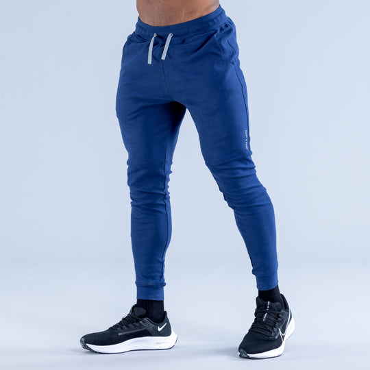 Blue tapered jogger pants with elastic cuffs and white drawstring waist