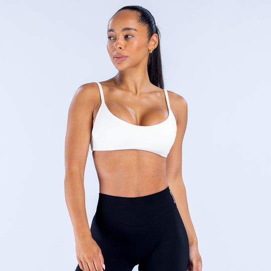 White scoop-neck sports bra front view, smooth fitted design