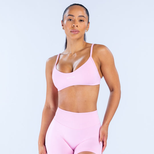 Pink scoop-neck sports bra with adjustable thin straps and racerback style