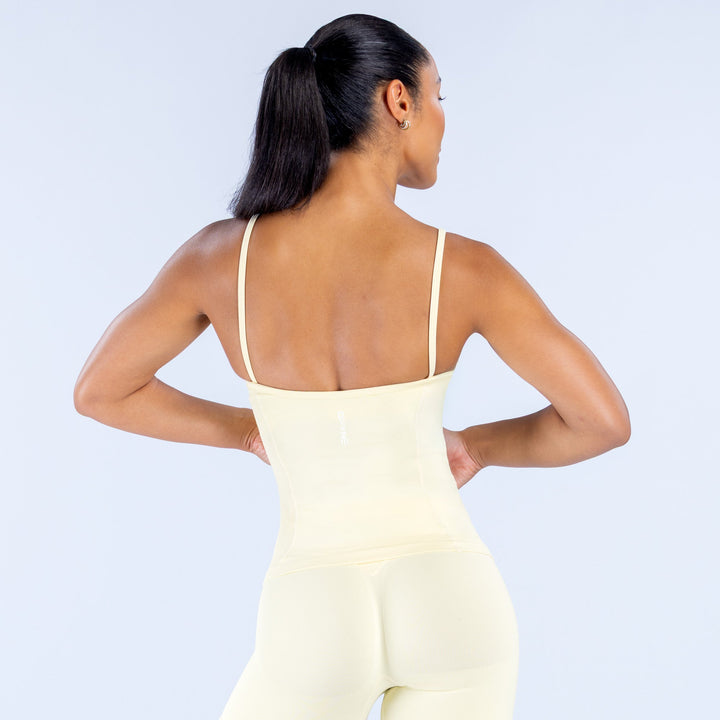 Cream scoop-neck sleeveless top with open back and thin straps, fitted