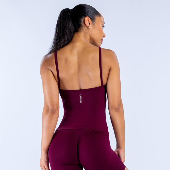Burgundy scoop-neck tank top with racer-back straps and small center-back logo