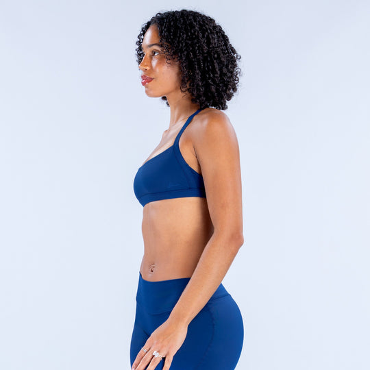 Blue sports bra with scoop front and minimal side coverage.