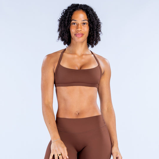 Dark brown strappy sports bra with scoop neckline and elastic underband