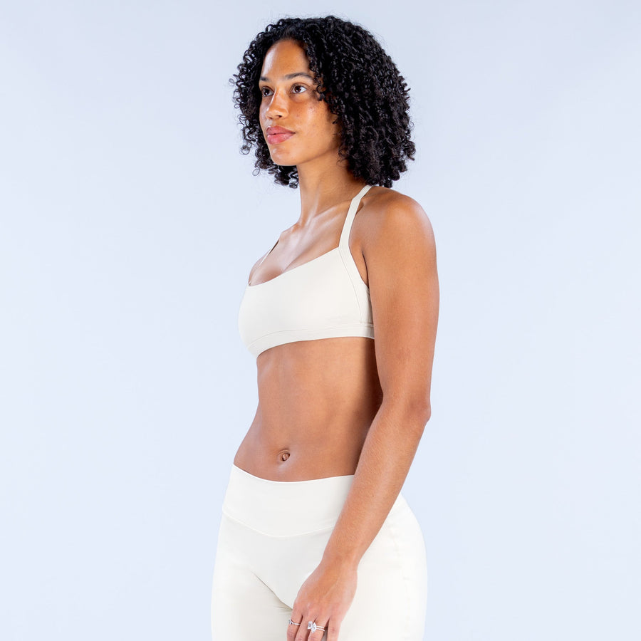 White sports bra with slim halter straps and scooped front