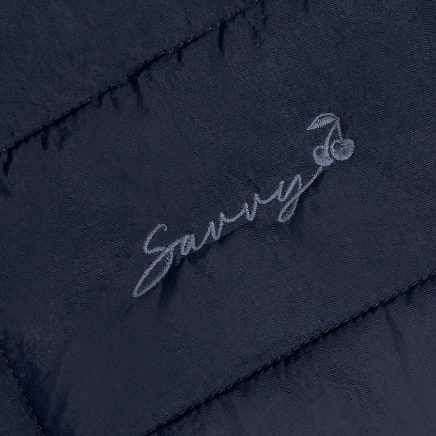 Embroidered script logo on dark quilted puffer bag panel