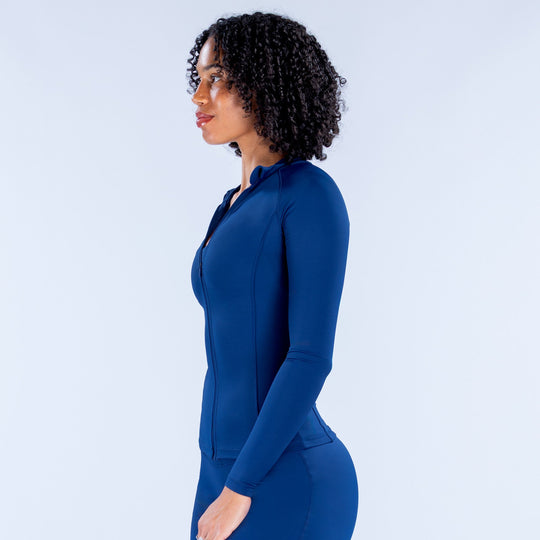 Women's blue fitted zip-up long-sleeve athletic jacket, side profile
