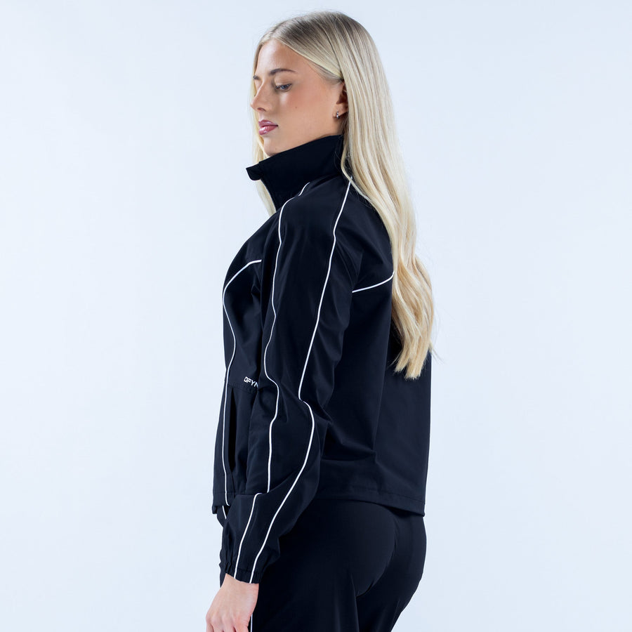 Women's black track jacket side view with white piping and zip front