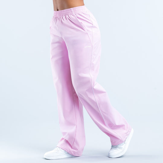 Pink track pants with elastic waistband and side seams, small logo on thigh